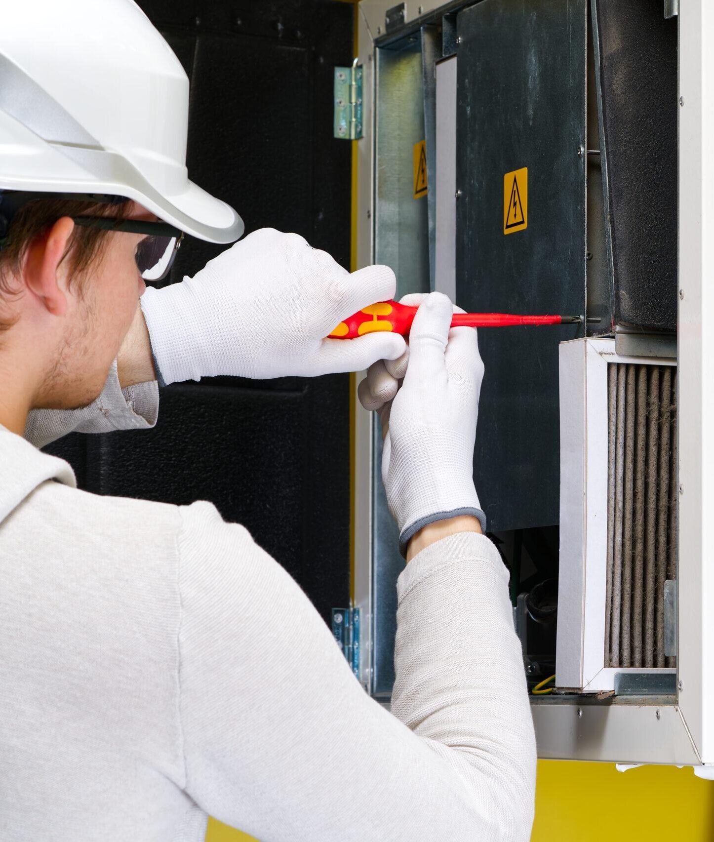 Technician checking electrical components in an air-handling unit