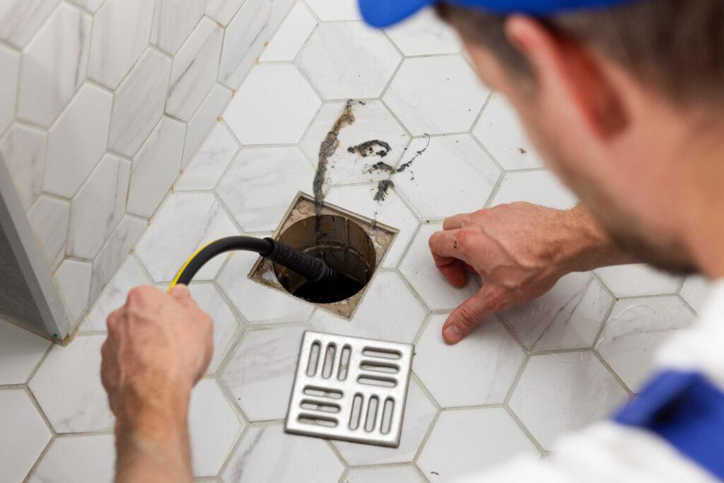 Technician clearing a shower drain